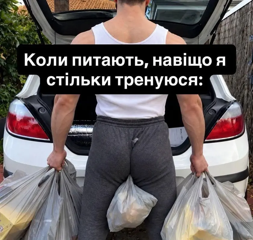 Мускулистый мужчина держит много тяжелых пакетов с покупками возле багажника машины
